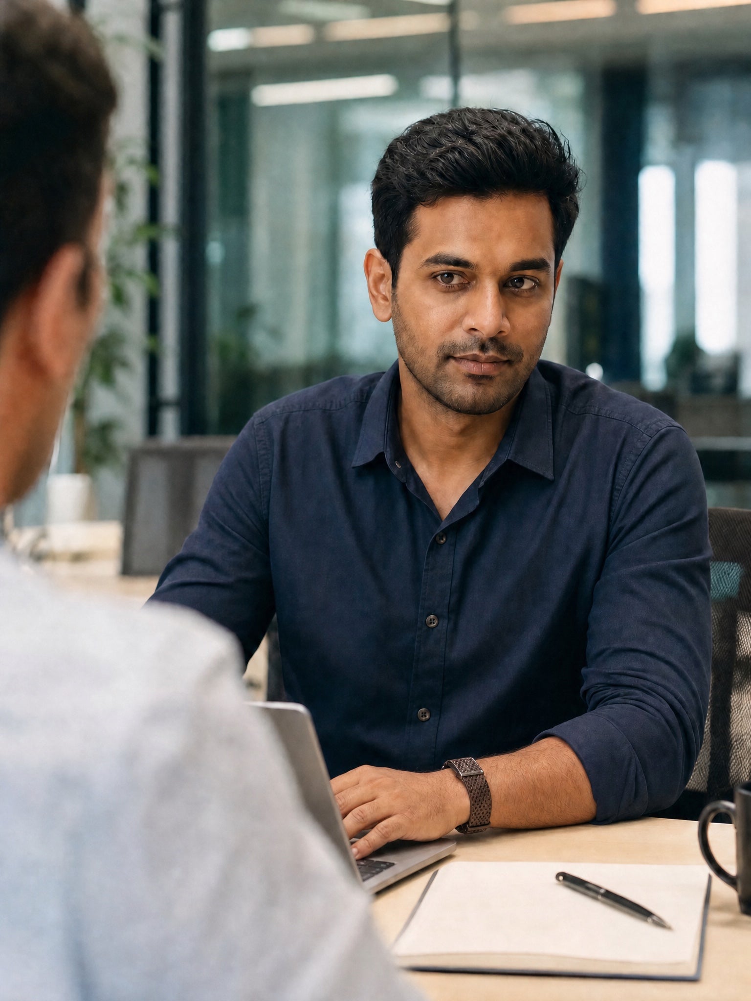 Client review at a meeting table, wellness band on his left wrist